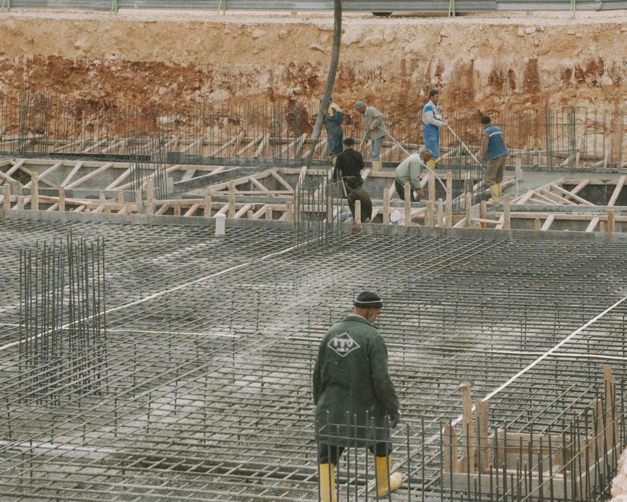 Workers building a foundation with rebar at a construction site. — concrete epoxy coating Omaha