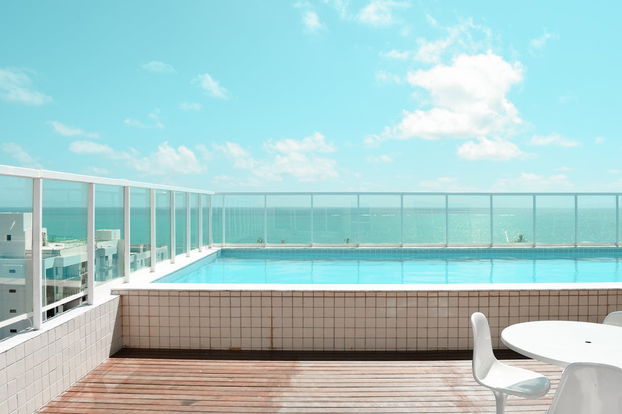 Serene rooftop infinity pool with stunning ocean view under a bright blue sky. — pool deck coating Omaha